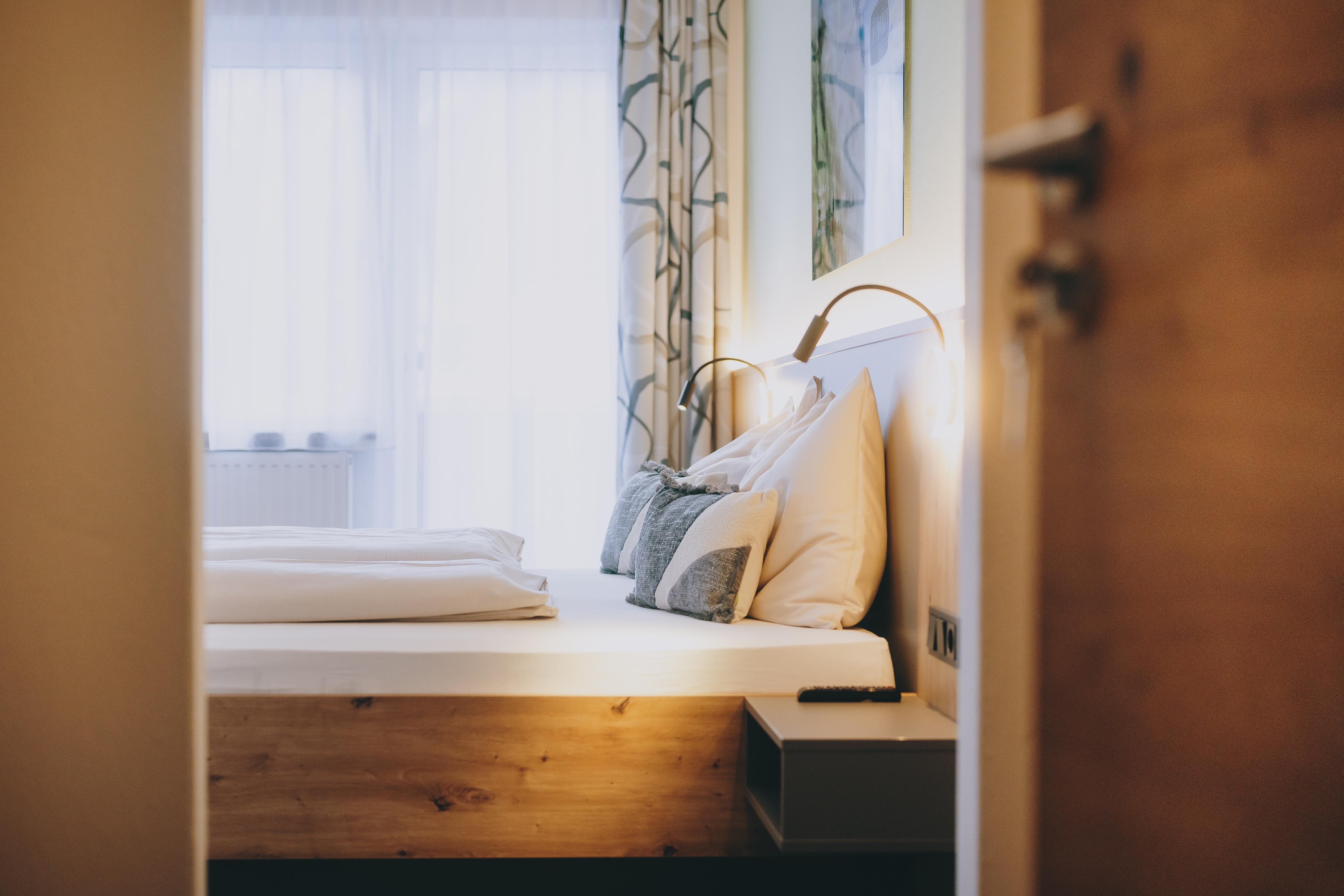 A cozy bedroom with a large bed and soft pillows.  
Plenty of daylight streams through the windows, creating a warm atmosphere.