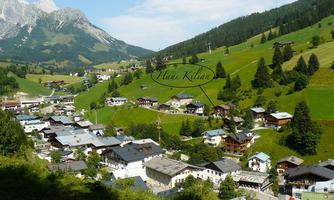 A tranquil mountain landscape with a picturesque village in the valley. Surrounded by green meadows and majestic mountains.