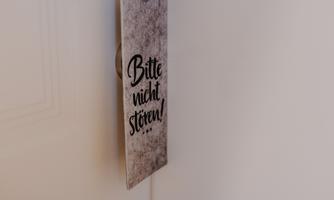A door sign with the inscription "Please do not disturb!" indicates that the room should not be entered. The sign has a simple yet appealing design.