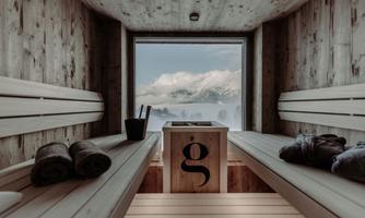 A modern sauna area with wooden paneling and a view of the mountains. Relaxed atmosphere with towels and a stylish sauna table.