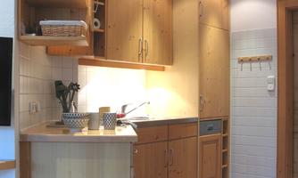 A bright kitchen with wooden furniture and modern appliances. The space is well-organized and offers plenty of storage.