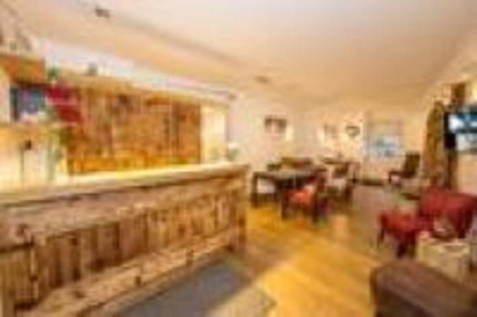 An inviting reception area with a wooden counter and cozy seating. The decor is bright and friendly, perfect for a relaxing stay.