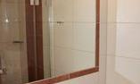 A modern bathroom with a large mirror and a stylish light bar. Fresh towels and hygiene products are placed on the sink.