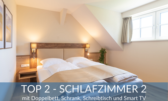 A modern bedroom with a double bed, a wardrobe, and a desk. Additionally, there is a smart TV in the room.