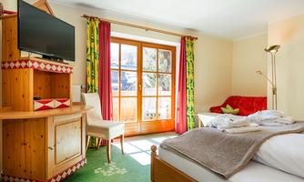 A cozy room with wooden interiors and a large window. The decor is bright and inviting, perfect for relaxation.