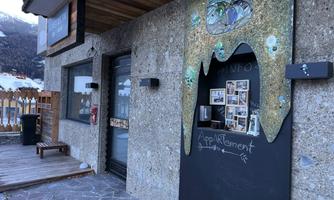 A creative entrance door to a building with a unique, melting decoration. Next to the door are windows with photo documentation and labels.