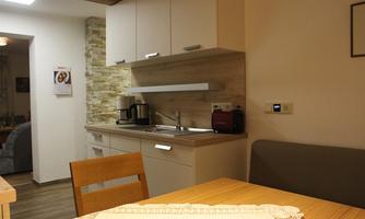 A modern kitchen with bright furniture and wooden elements. On the countertop, there is a coffee machine and a toaster.
