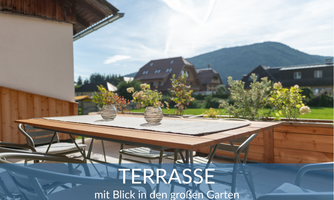 An inviting terrace with a table and chairs. In the background, there is a view of a large garden and a picturesque landscape.