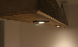 A wooden strip with integrated lights. The background is subtly and softly lit.