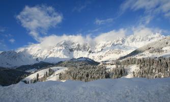 An impressive mountain landscape with snow-capped peaks and blue skies. Nature is calm and winterly beautiful.
