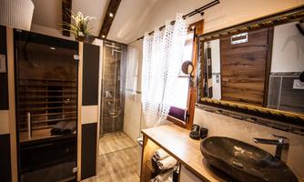A modern bathroom with a sauna and a shower. Elegant details and wood paneling create a relaxed atmosphere.