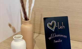 A stylish decoration with two vases and a welcome sign. The vases contain decorative plants and create a cozy atmosphere.