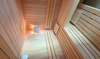 A cozy sauna with wooden benches and gentle lighting. The atmosphere is relaxing and inviting.