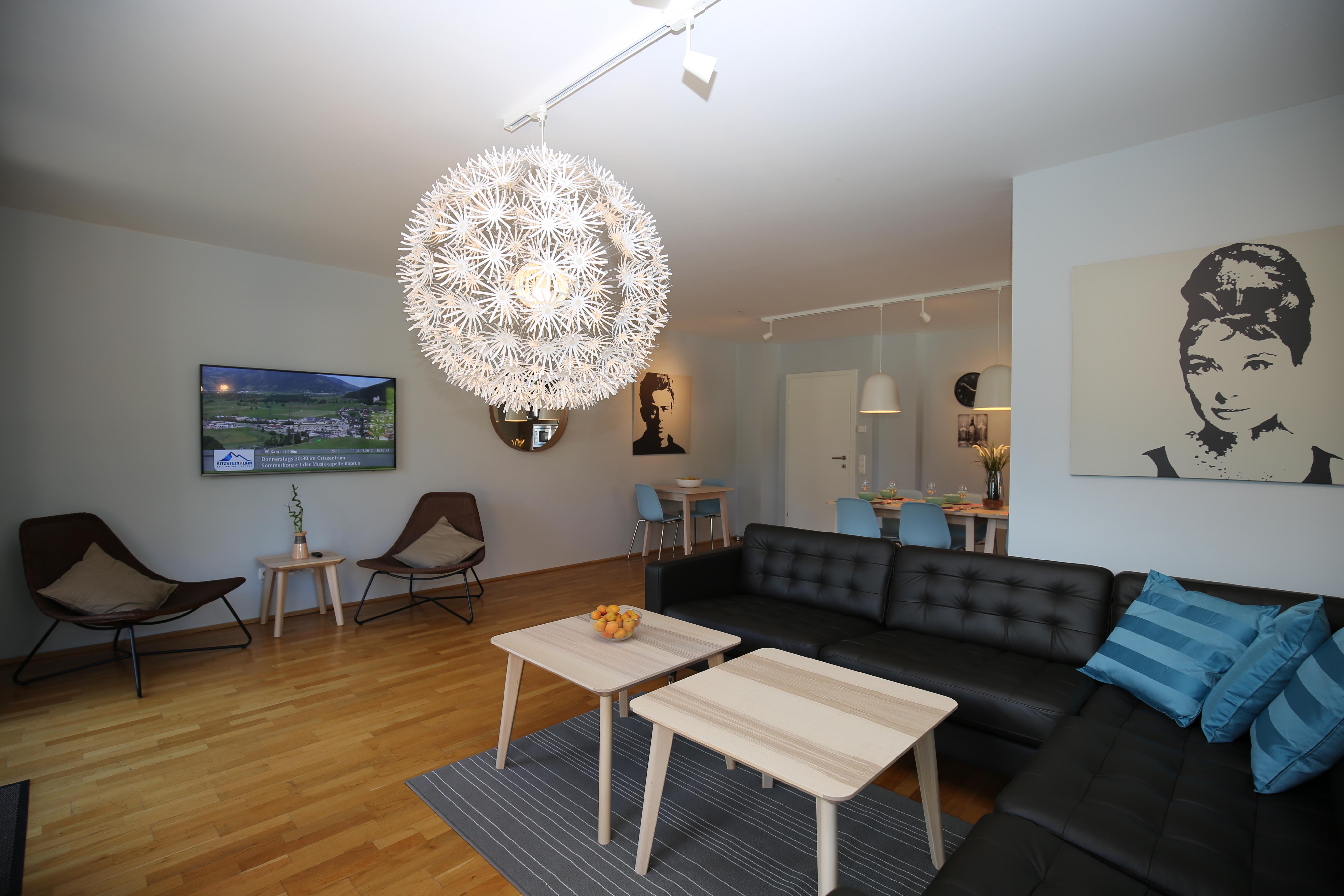 A modern living room with elegant lighting and stylish furniture. The space is bright and inviting, perfect for relaxed moments.