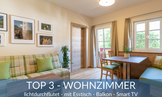 A bright living room with a dining table and a balcony. It features a cozy seating area and a Smart TV.