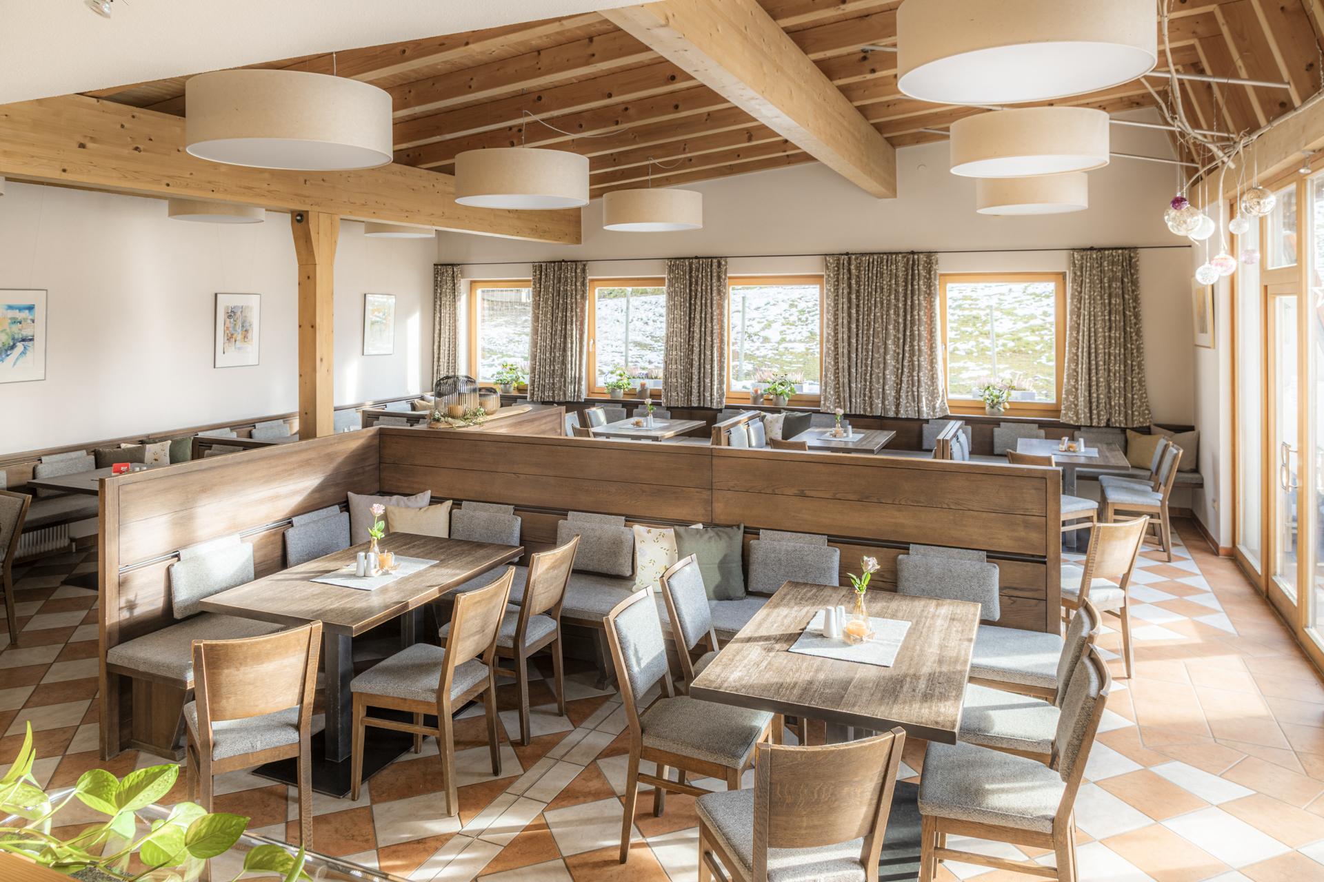 A cozy restaurant with wooden furniture and large windows. The bright tables are beautifully set and invite you to linger.