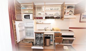 A modern kitchen with wooden cabinets, a refrigerator, and a dishwasher. The decor is neatly and functionally designed.