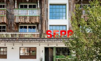 A modern building with wooden elements and large windows. In the foreground, the inscription "SEPP" is clearly visible in red color.