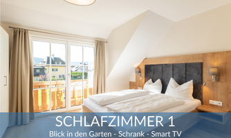 A modern bedroom with a large window overlooking the garden. It is equipped with a double bed, a wardrobe, and a smart TV.