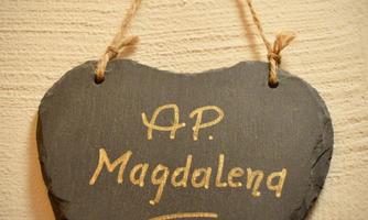 A heart-shaped slate plaque with the inscription "A.P. Magdalena" in golden lettering. It hangs from a jute ribbon.