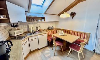 A bright kitchen with a dining area and a cozy seating area. The skylights provide plenty of natural light.