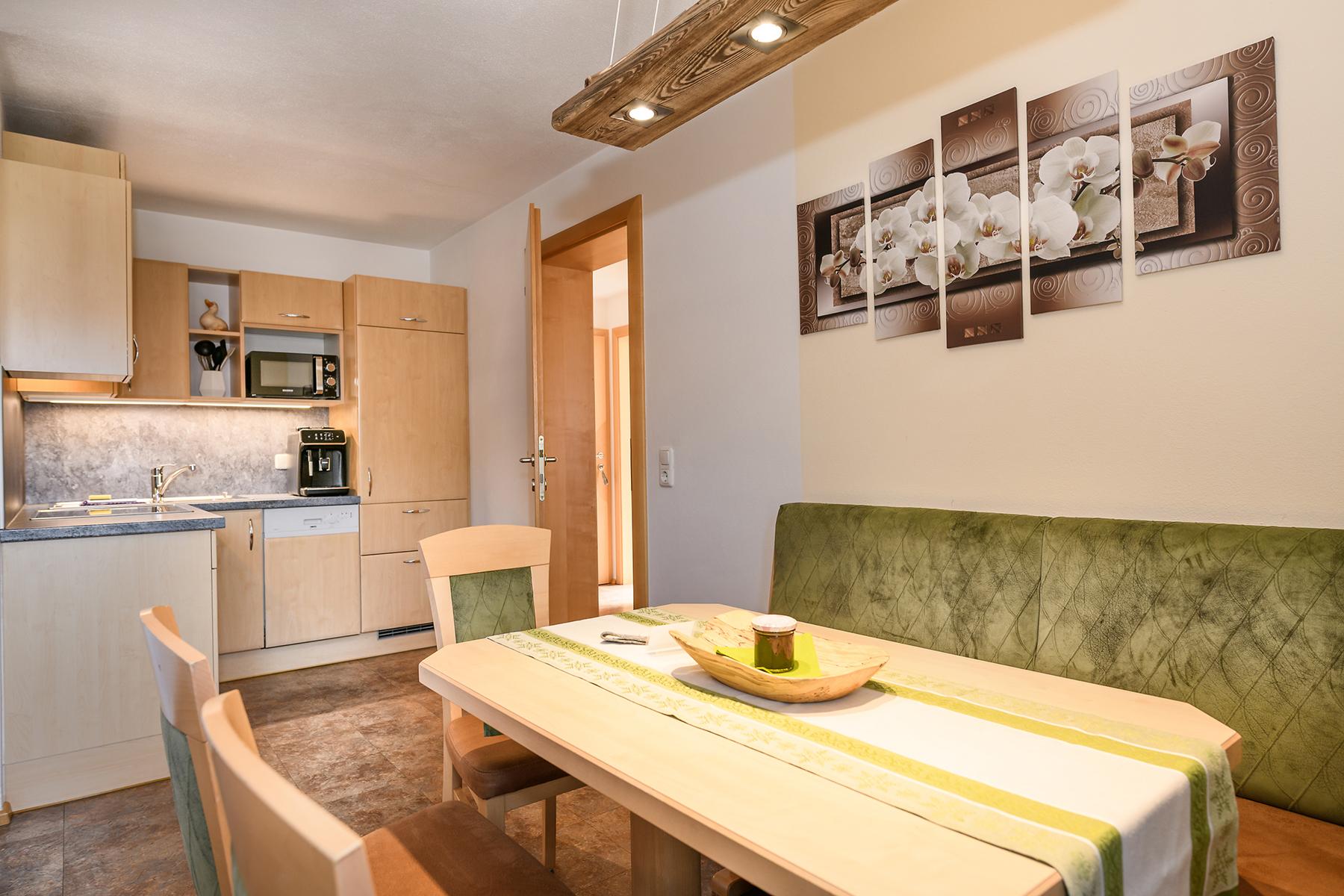 A modern and well-equipped kitchen with a cozy dining area. The couch can be converted into a sofa bed. The ski lifts, mountain railways, and the swimming pool are just a few meters away.