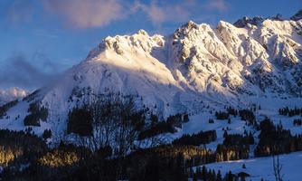 An impressive mountain panorama with snow-covered peaks. The sunlight creates a beautiful interplay of light on the landscape.