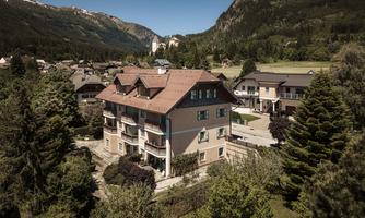 A modern building in a picturesque rural setting. Surrounded by trees and with a view of the mountains in the background.