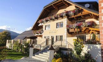 A charming house with colorful flower balconies and beautiful garden landscaping. The atmosphere is inviting and friendly.