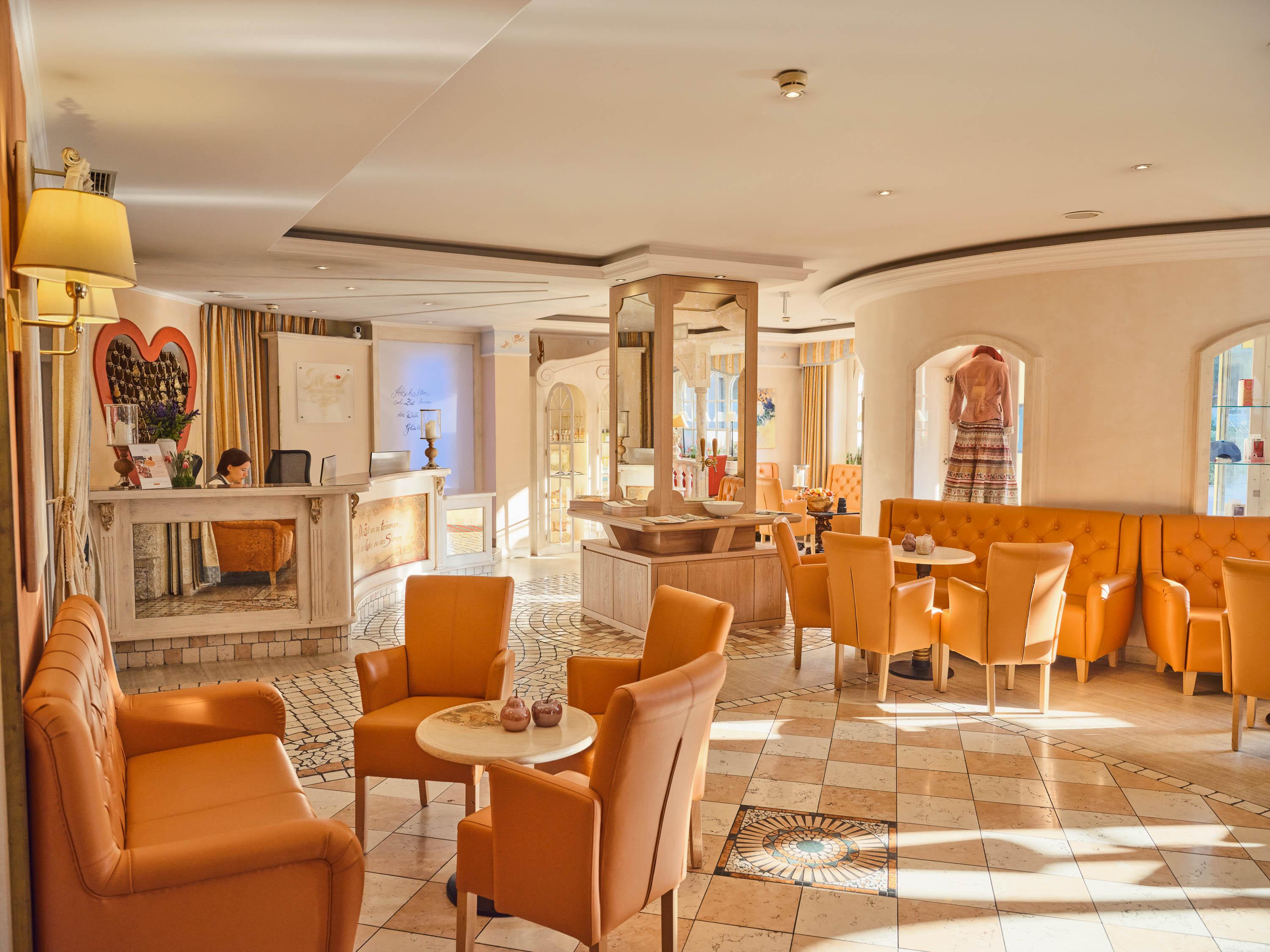 An inviting interior with orange armchairs and tables. The room feels bright and spacious with a cozy atmosphere.