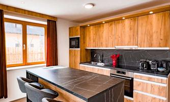 Modern kitchen with wood and marble details. A large kitchen island seating area with bar stools creates an inviting atmosphere.