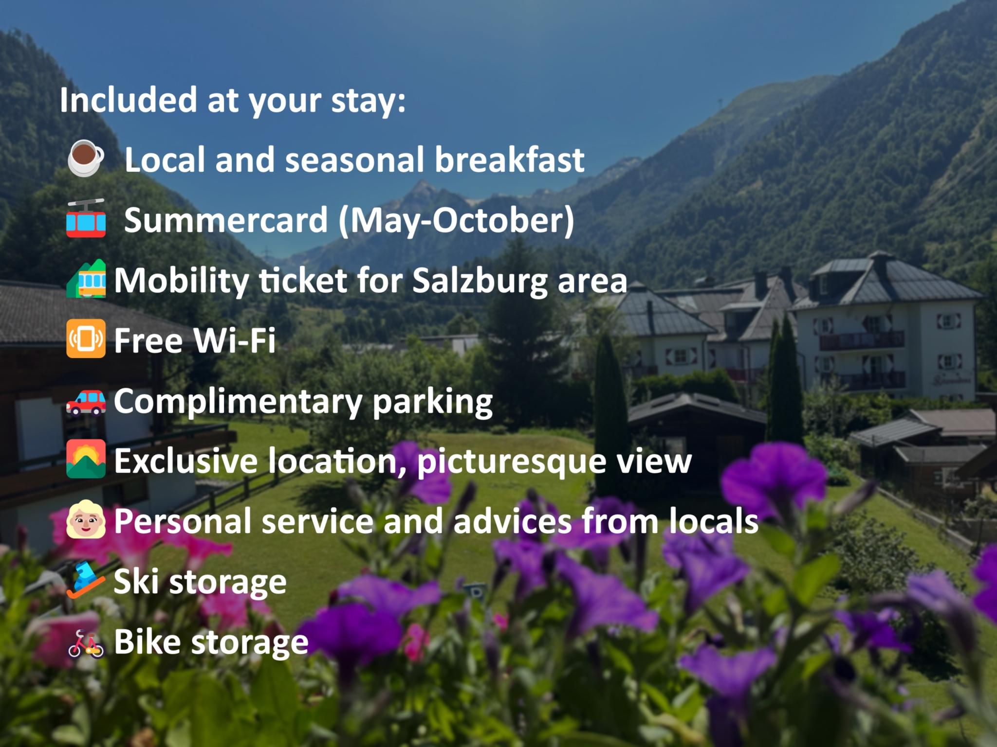 The image shows a picturesque landscape with mountains in the background and a blooming garden in the foreground. There is accommodation located in an attractive setting.