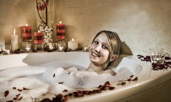 A relaxing bathtub with foamy water and rose petals. Candles and a happy smile create a cozy atmosphere.