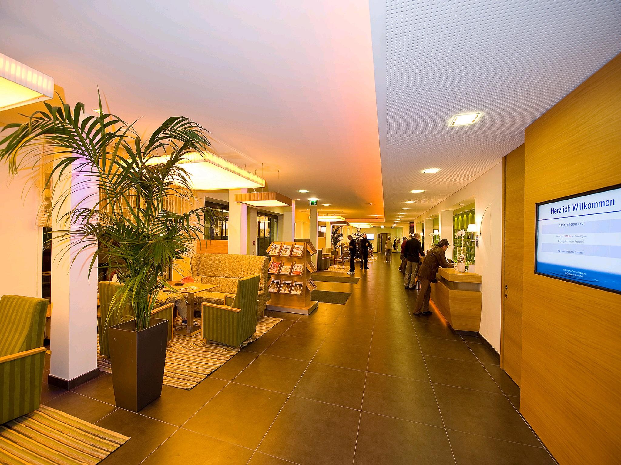 A modern reception area with comfortable seating and large window surfaces. The lighting creates an inviting atmosphere.