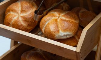 Fresh bread rolls in a wooden box. The rolls are crispy and deliciously presented.
