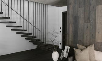 A modern living room with a minimalist design. The wooden steps and the neutral color palette create a harmonious atmosphere.