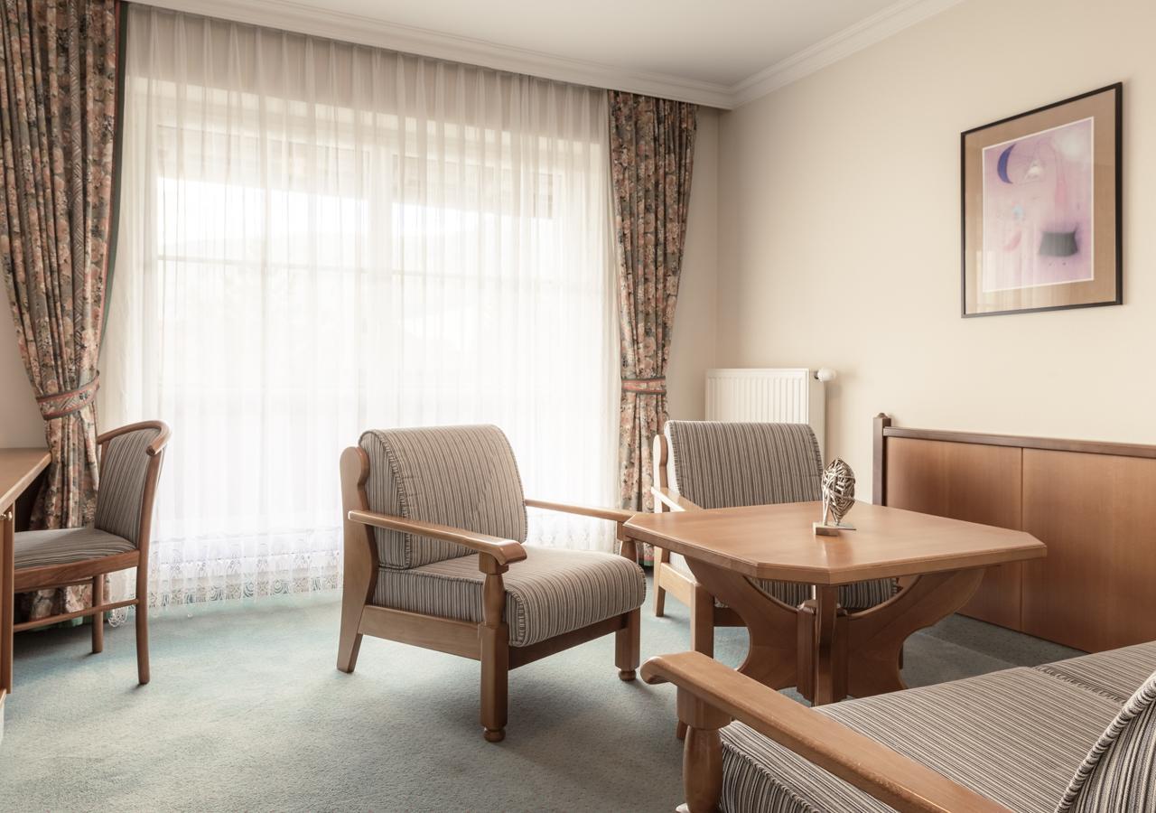 A bright living room with wooden furniture and striped chairs.
Large windows let in plenty of daylight and create an inviting atmosphere.