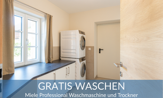 A bright laundry room with Miele washing machine and dryer. Large windows provide plenty of daylight.