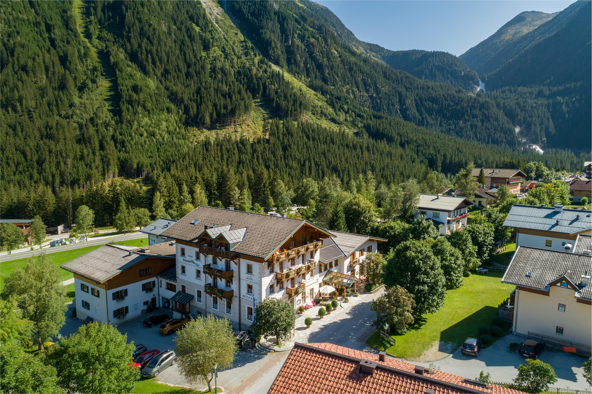 A picturesque hotel set amidst a green landscape with mountains in the background. The surroundings are quiet and inviting, ideal for a relaxing stay.
