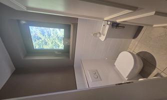 Separate toilet, small sink, and a window.