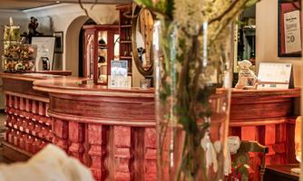 An inviting interior with a red counter and lush flower arrangements. Cozy decorative elements create a warm atmosphere.