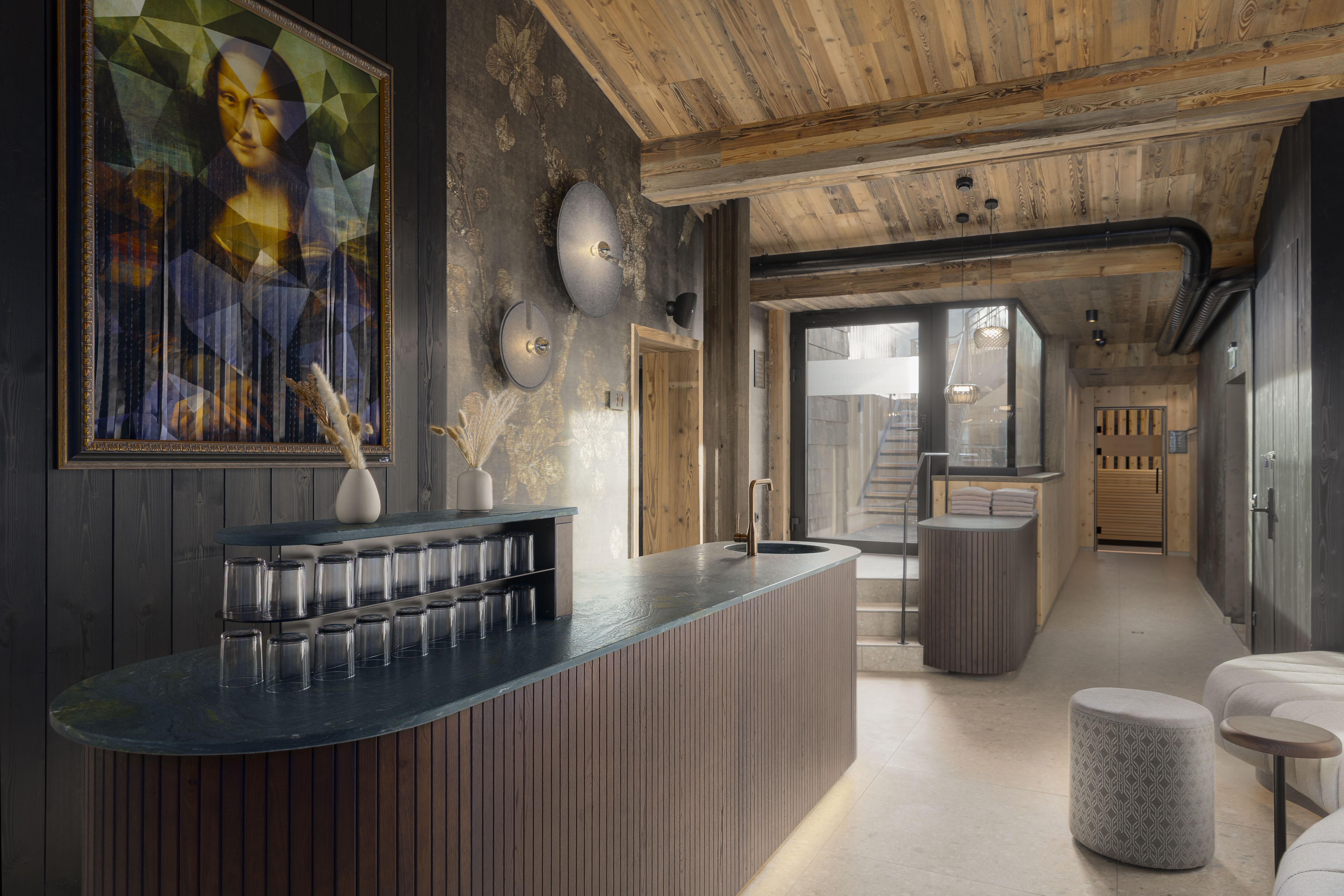 A modern reception area with a wooden ceiling and stylish design. An artistic picture hangs on the wall, and there are comfortable seating options.