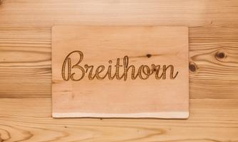 A wooden sign with the inscription "Breithorn". The background is made of light, natural wood.