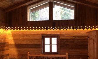 A cozy room with wood paneling and large windows. Soft lighting accentuates the warm wood tones.