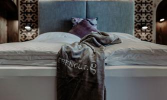 A cozy bedroom with a modern bed and a soft blanket. Gentle lighting and stylish accents create a relaxed atmosphere.