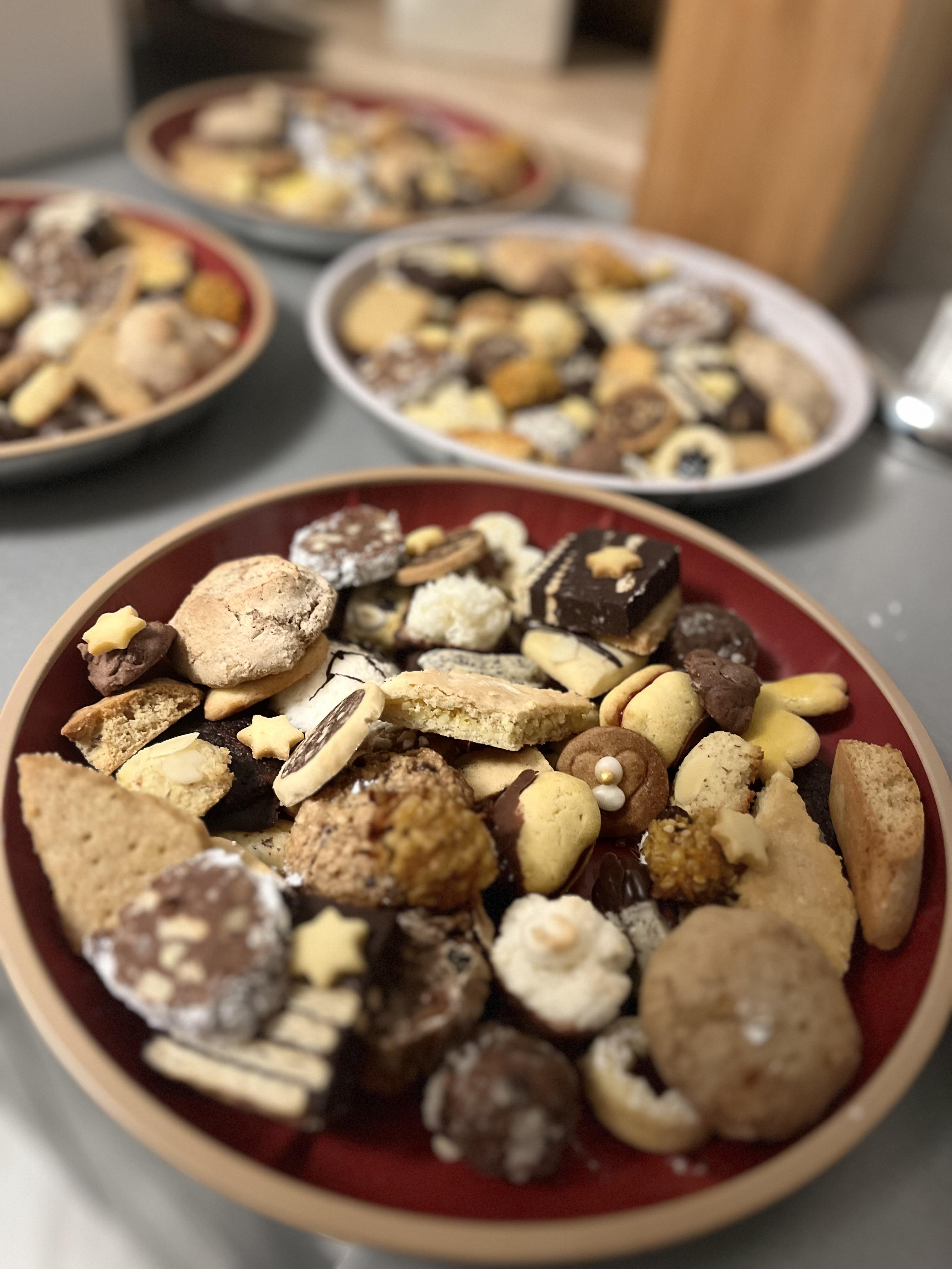 A plate with various types of cookies and biscuits in different shapes and colors. The treats are attractively arranged and invite you to snack.