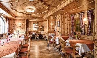 A cozy restaurant with wooden paneling and a rustic atmosphere. The tables are set and usher in an inviting ambiance.
