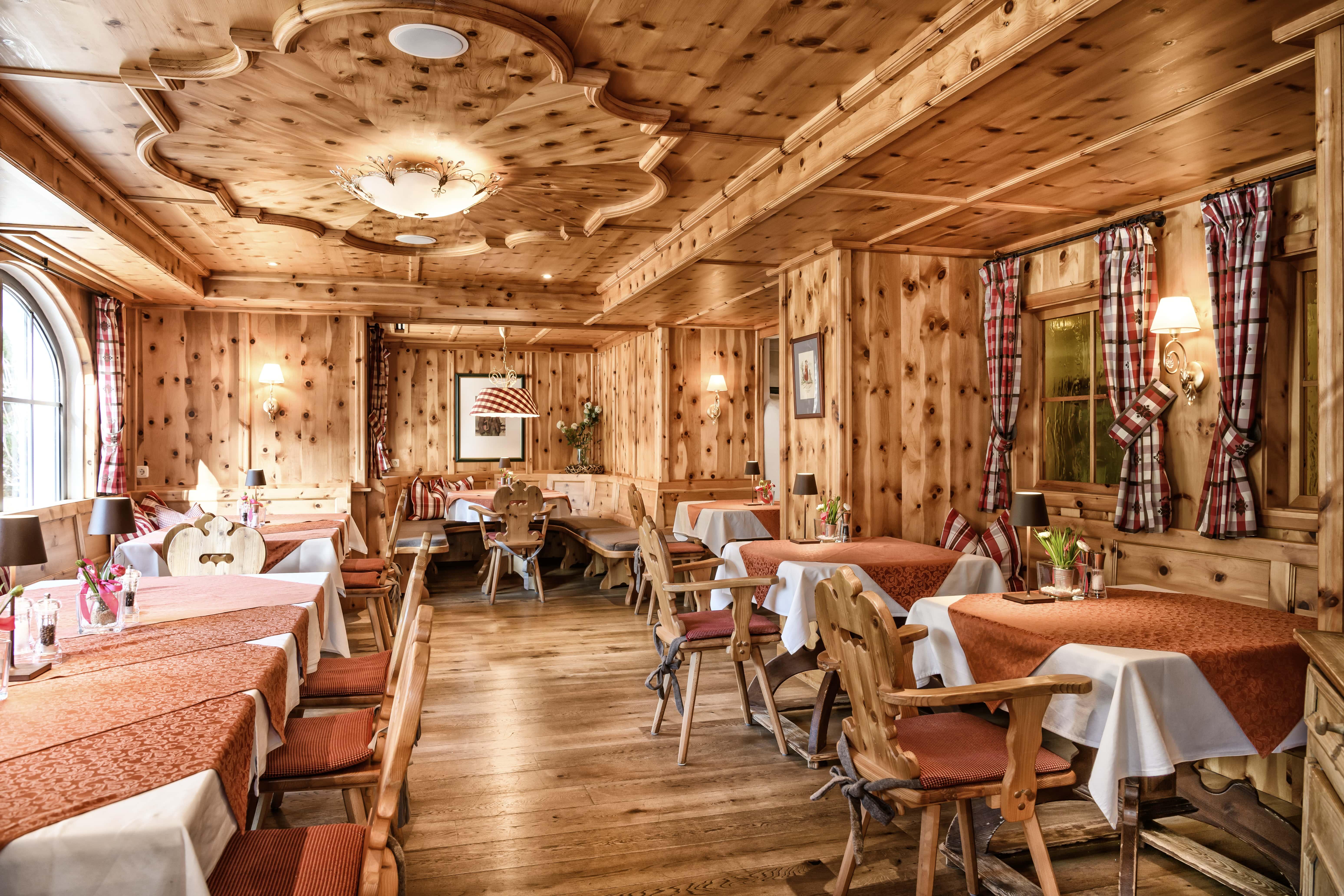 A cozy restaurant with wooden paneling and a rustic atmosphere. The tables are set and usher in an inviting ambiance.