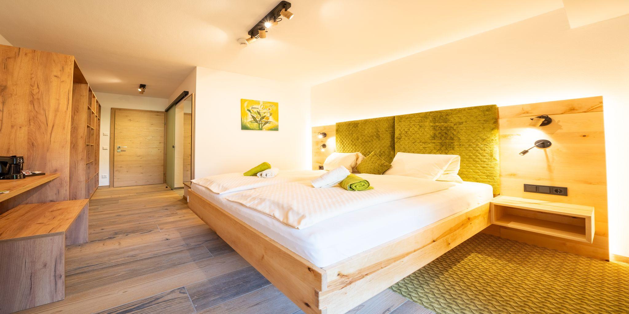A modern bedroom with a double bed and bright wood design. The room is well-lit and offers a cozy atmosphere.