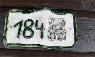 A house number with the number 184 is visible. Next to it is an image of a deer in front of a forest.